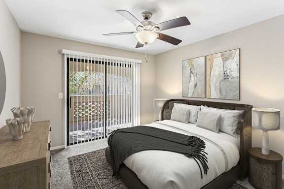 A bedroom with a large bed and a ceiling fan. at San Montego Apartments, Mesa