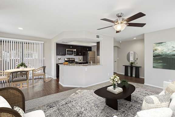 A modern living room with a dining area and kitchen in the background. at San Montego Apartments, Mesa, 85206
