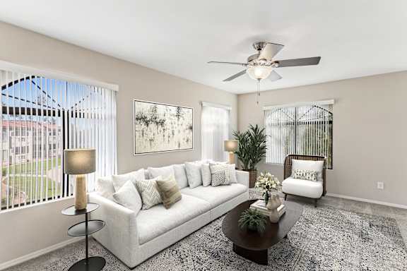 A living room with a white couch, a coffee table, and a ceiling fan. at San Montego Apartments, Mesa, AZ, 85206