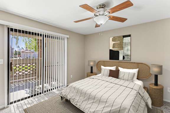 A bedroom with a bed, two lamps, and a ceiling fan. at San Montego Apartments, Arizona