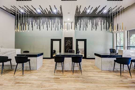 a dining room with a table and chairs and a lobby with large windows at Ventana Oaks Apartments, Austin, Texas
