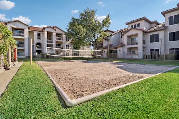 A large, empty lot sits between two apartment buildings.