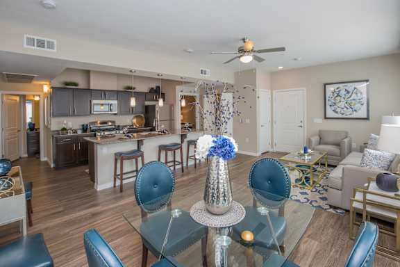 a living room and kitchen with a dining room table and chairs at The Passage by Picerne, Henderson, NV