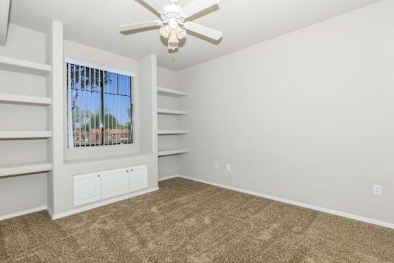 an empty living room with carpet and a ceiling fan at The Aliante by Picerne, Scottsdale, Arizona