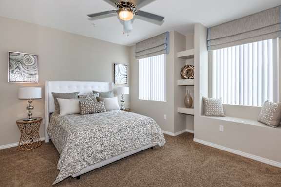 a bedroom with a bed and a ceiling fan