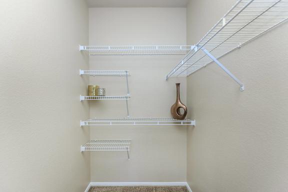 an empty closet with shelves and a guitar on the wall at The Covington by Picerne, Nevada, 89139