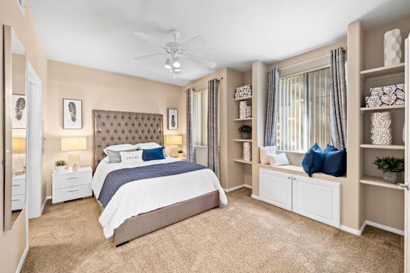 A bedroom with a large bed and a ceiling fan.