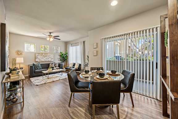 A modern living room with a dining table set for four.