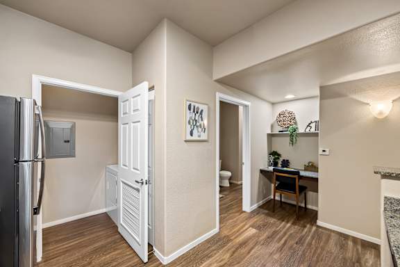 A kitchen with a refrigerator, a table, and a chair.