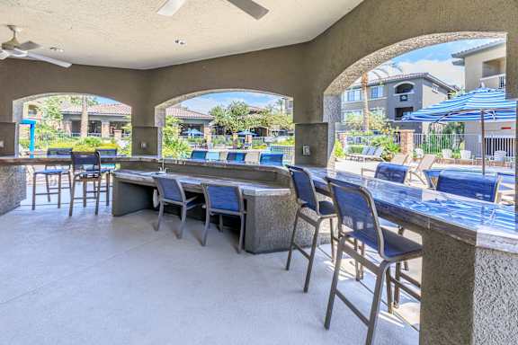 patio bar with seating and tables with umbrellas at The Preserve by Picerne, Nevada