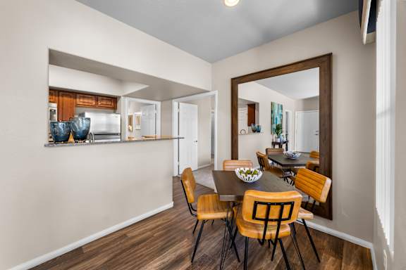 A dining room with a table and chairs.