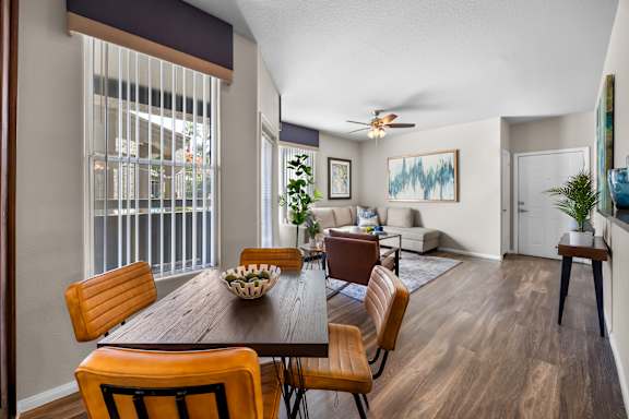 A dining room with a wooden table and chairs.