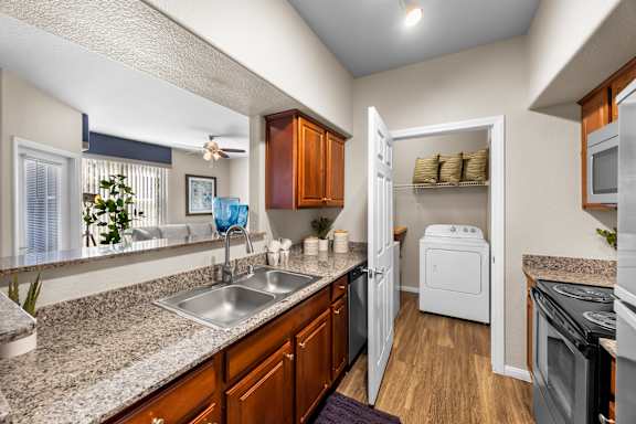 A kitchen with a sink, refrigerator, and oven.