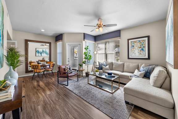 A living room with a white couch and a glass coffee table.