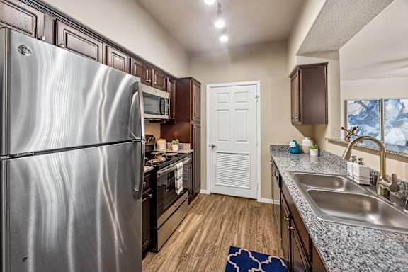 A kitchen with a stainless steel refrigerator and a sink.