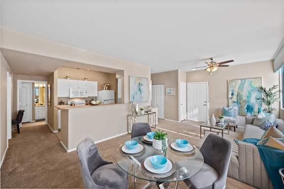 A well-lit, modern living room with a dining table set for two.