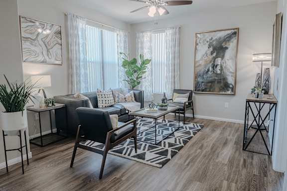 Living Room with Black Leather Couch at The Summit by Picerne Apartments, Henderson, NV