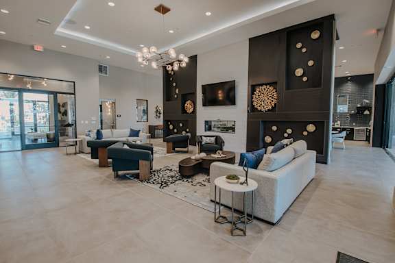 Spacious clubhouse with high ceiling, lots of cozy seating, and fireplace at Level 25 at The Curve by Picerne, Las Vegas, NV