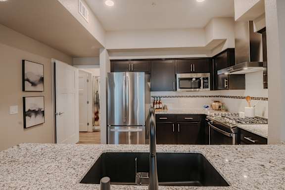 Kitchen with white cabinets and a stainless steel refrigerator at Level 25 at The Curve by Picerne, Las Vegas, NV, Nevada , 89148