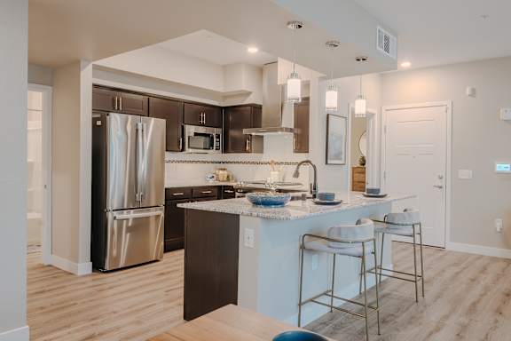 A modern kitchen with a stainless steel refrigerator and a white countertop.