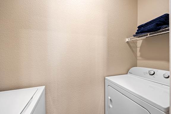 A white washing machine and dryer in a laundry room.