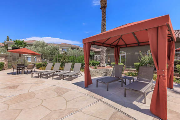 A patio with a red canopy and chairs.