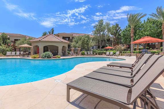 A poolside area with sun loungers and a gazebo.
