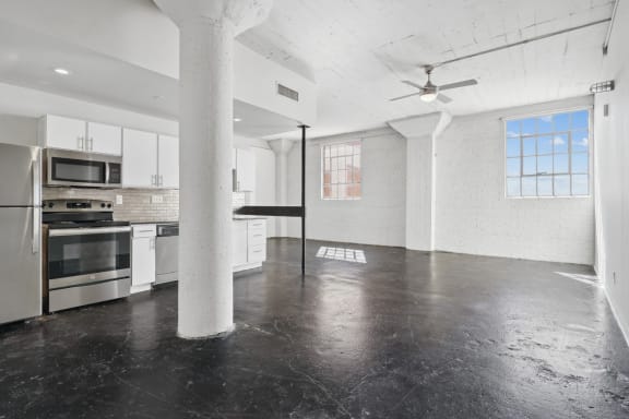 an empty kitchen with white cabinets and stainless steel appliances