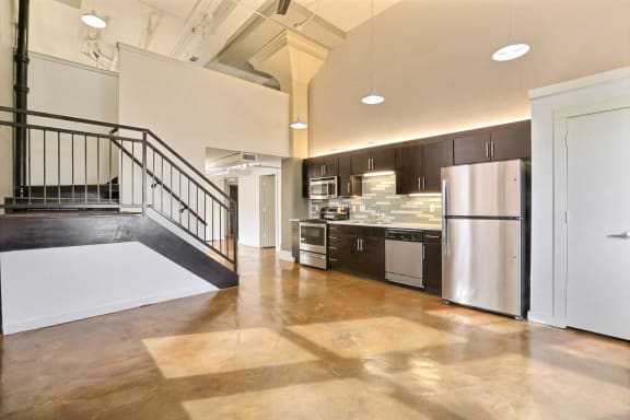 a kitchen with a stainless steel refrigerator and a staircase