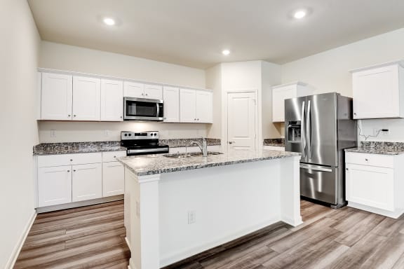 a kitchen with an island and stainless steel appliances