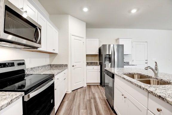 a kitchen with white cabinets and black appliances