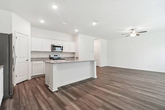 A kitchen with white cabinets and a microwave oven.