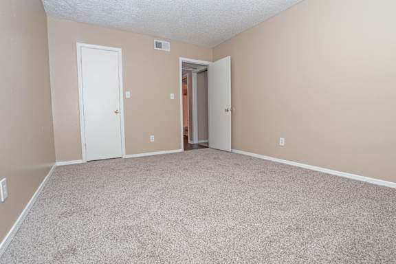 A bedroom room with a carpeted floor and closet  at The Creole Apartments in Shreveport, LA