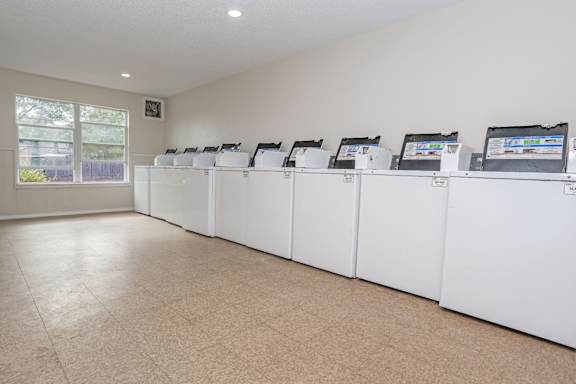 A row of washing machines inside an onsite laundry facility at The Creole Apartments in Shreveport, LA