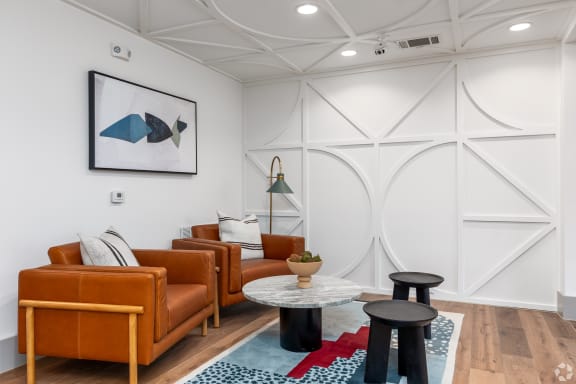 Building interior social space with couch chairs and table at Era apartments in Denton, TX