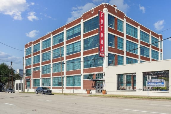 a large brick building with a red sign on the side of it