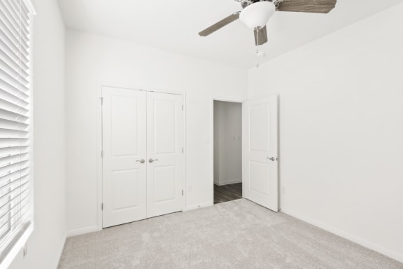 a bedroom with one closet and a ceiling fan
