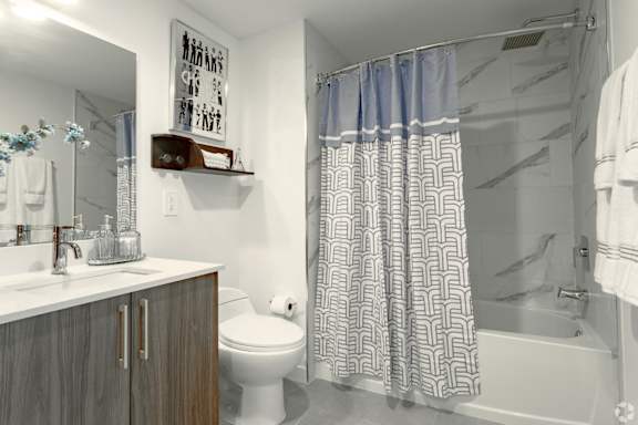 Modern bathroom with a toilet, sink, and shower in our model 2 bedroom apartment at Hollywood Heights on the Boulevard Luxury Apartments in Hollywood, FL