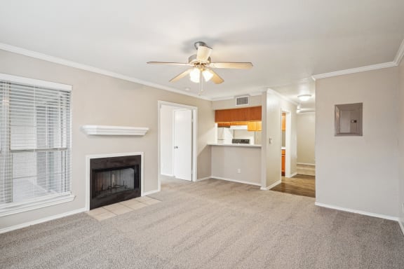 Unfurnished A4 floor plan living room with a fireplace and mantel, ceiling fan, and window Noel on The Parkway in Dallas, TX