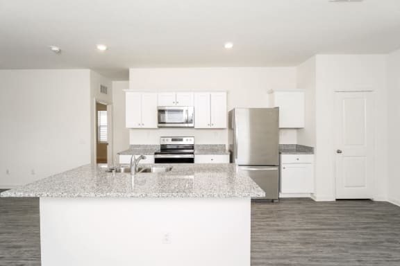 a kitchen with white cabinets and a granite counter top
