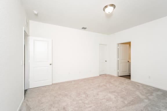 a bedroom with white walls and carpet