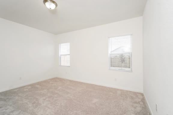 master bedroom with white walls and 2 windows