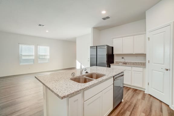 open kitchen with granite counter top, wood floor and modern appliances