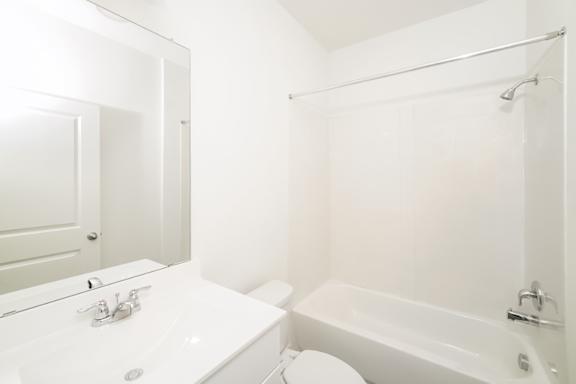 A white bathroom with a sink, toilet, and bathtub.