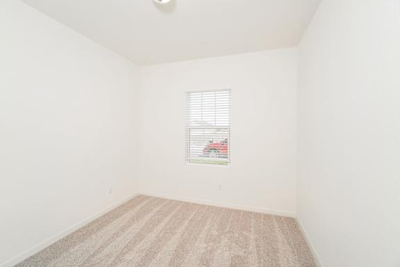 A room with a car picture on the window blinds.