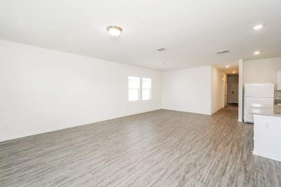 Empty room with wooden floor and white walls.