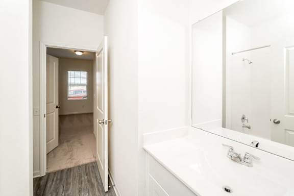 A bathroom with a white sink and a mirror.