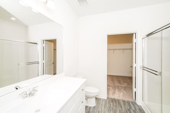 A white bathroom with a toilet, sink, and mirror.