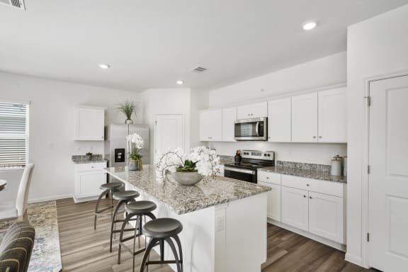 a kitchen with white cabinets and a granite counter top