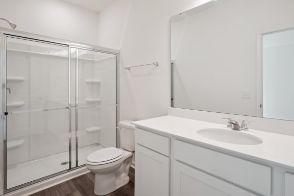 a white bathroom with a shower sink and toilet
